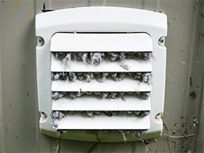 Before cleaning: Clogged dryer vent filled with lint, posing fire risk in Cleveland home.